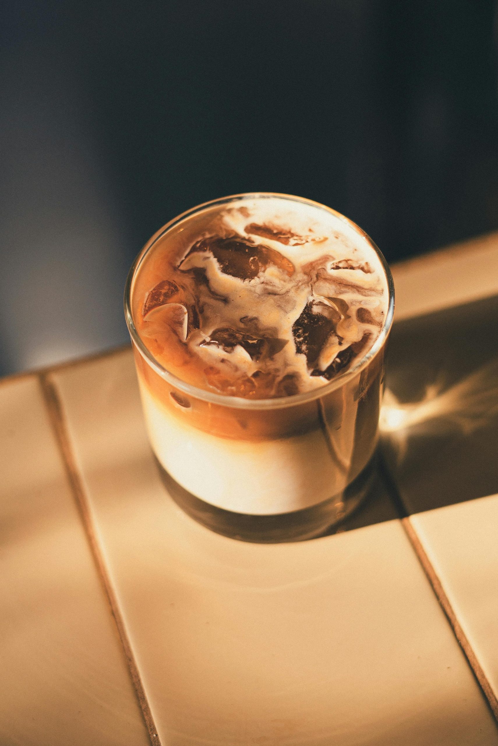 A delicious iced coffee with cream, perfect for summer refreshment, captured on a sunny countertop.